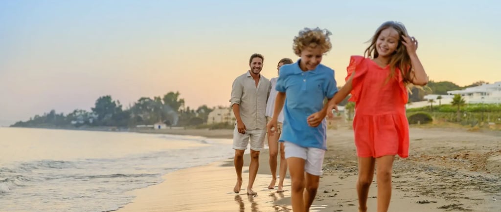 A happy family with young children enjoys a sunset walk on a sandy beach