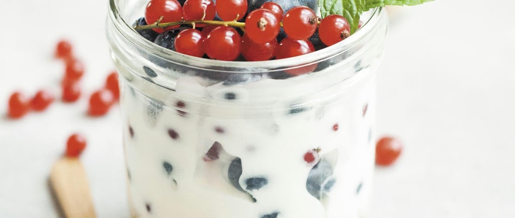Glass with curd, blue berry, mint and spoon on the side