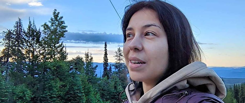 Woman enjoying the mountain views after returning home to Big White, British Columbia.