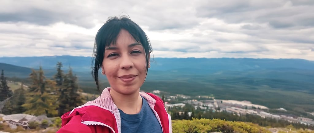 Self-portrait on a mountain overlooking Big White, British Columbia, under a cloudy sky.