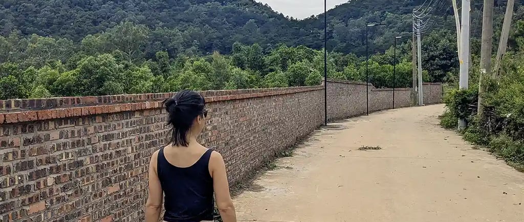 Walking near a retreat center surrounded by forested hills in northern Vietnam