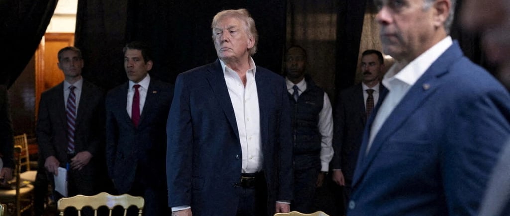 a man in a suit and tie standing in front of a group of people