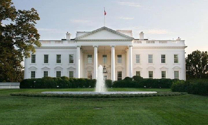 a large white house with a fountain in front of it