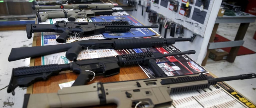 guns are lined up on a table in a store