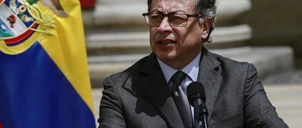 a man in a suit and tie is speaking into a microphone