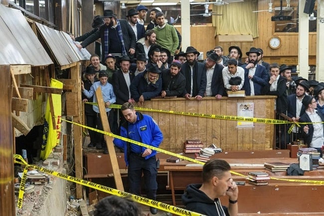 a man in a suit and tie is standing in front of a group of people