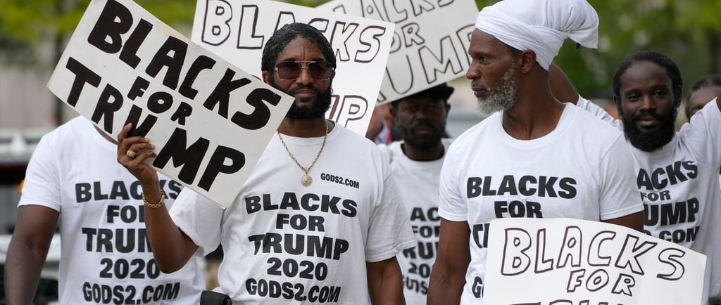 Black Americans holding signs that say "blacks for Trump"
