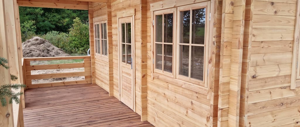 Moderne prefab blokhut als vakantiewoning of gastenverblijf met overdekte houten veranda