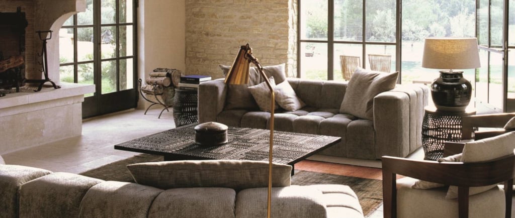 wall, sofa, floor in the same warm neutral family, light moving across