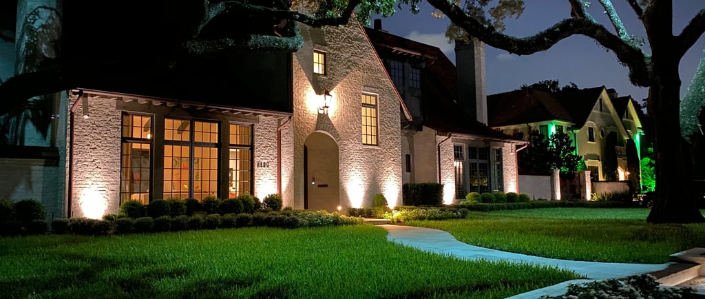 landscape lighting on a nice house facade and lights on trees and steps