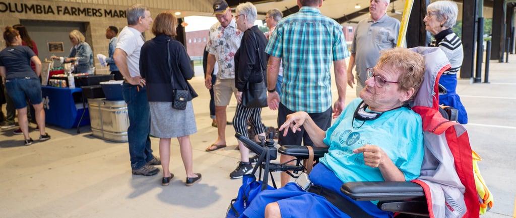 Person in a automatic wheelchair next to a small crowd of people