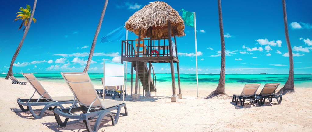 a beach with chairs and a life guard post in punta cana