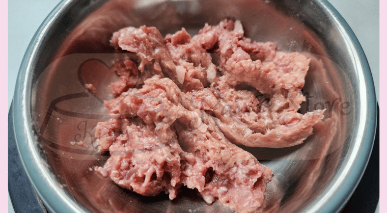 An image of raw cat food in a stainless steel bowl