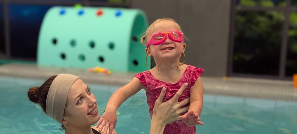  жінка в купальнику і дитина в басейні