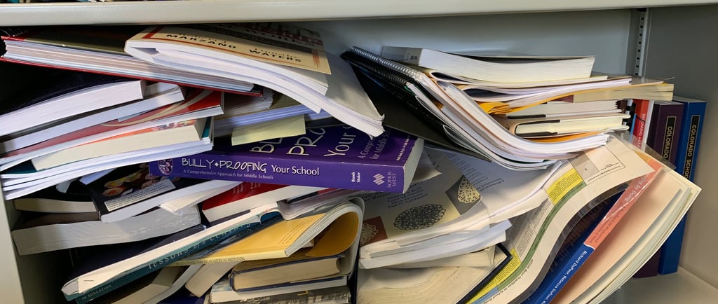 Books piled haphazardly on shelf