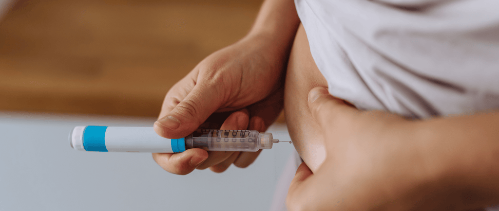 Woman administering IVF hormone injection in lower abdomen