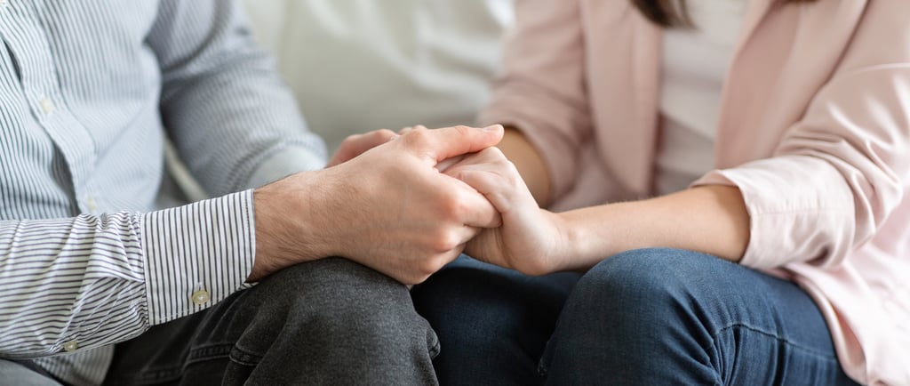 Couple holding hands and discussing fertility challenges