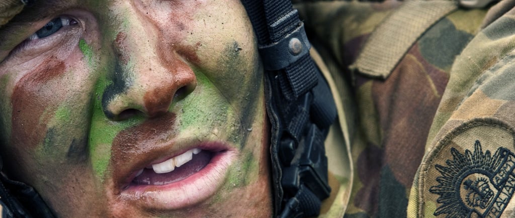 a soldier's face is covered in camouflage