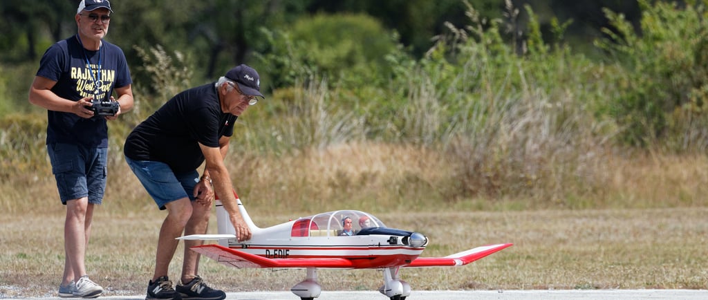 Two men ready to fly an RC airplane.
