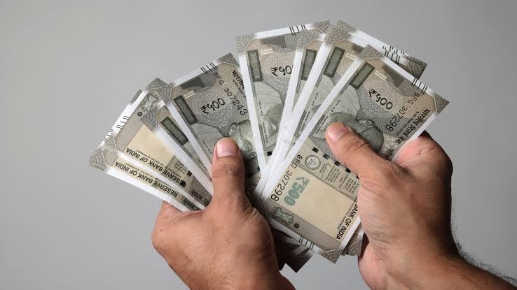 a man holding a stack of money bills