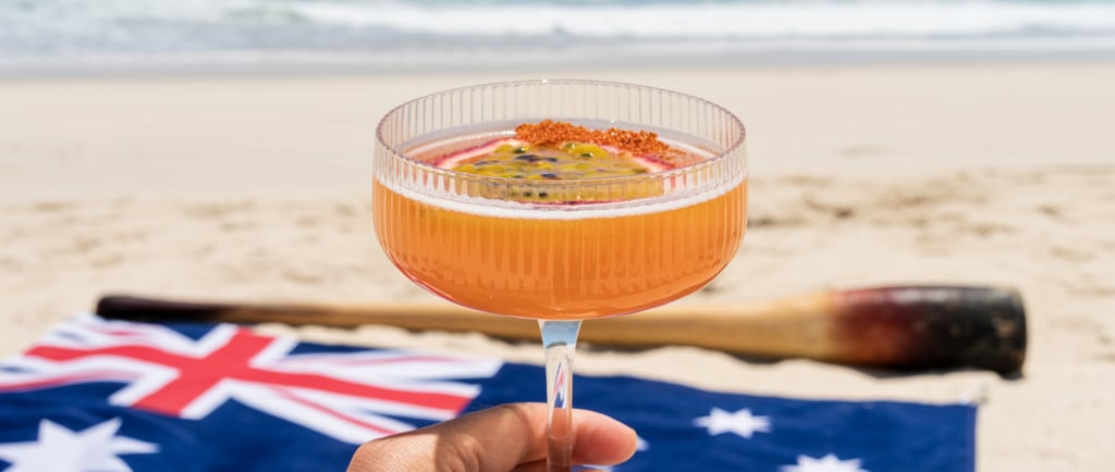 Holding a a Killer Bee cocktail against an Australia day beach scene with the flag and digeridoo