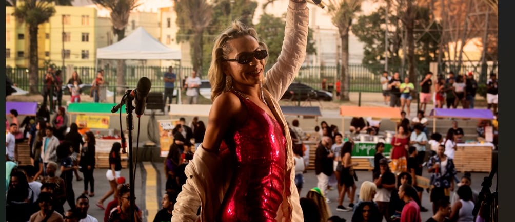 a woman in a red dress and sunglasses on a stage