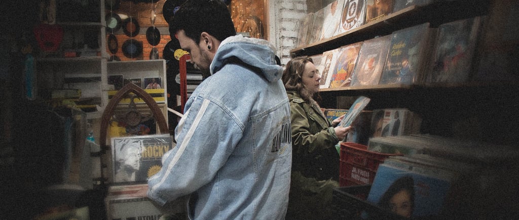 a man in a blue jacket is looking at a book
