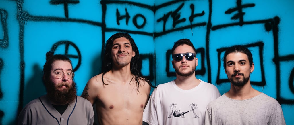 a group of men standing in front of a blue wall