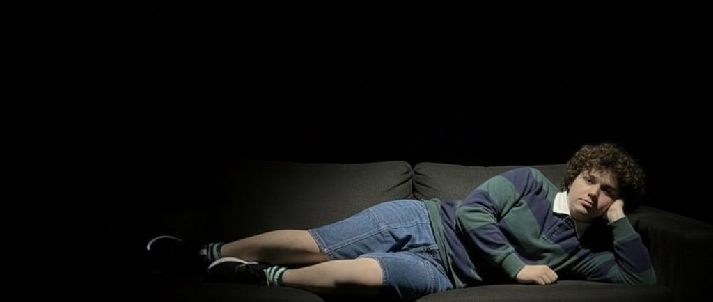 a man laying on a couch in the dark