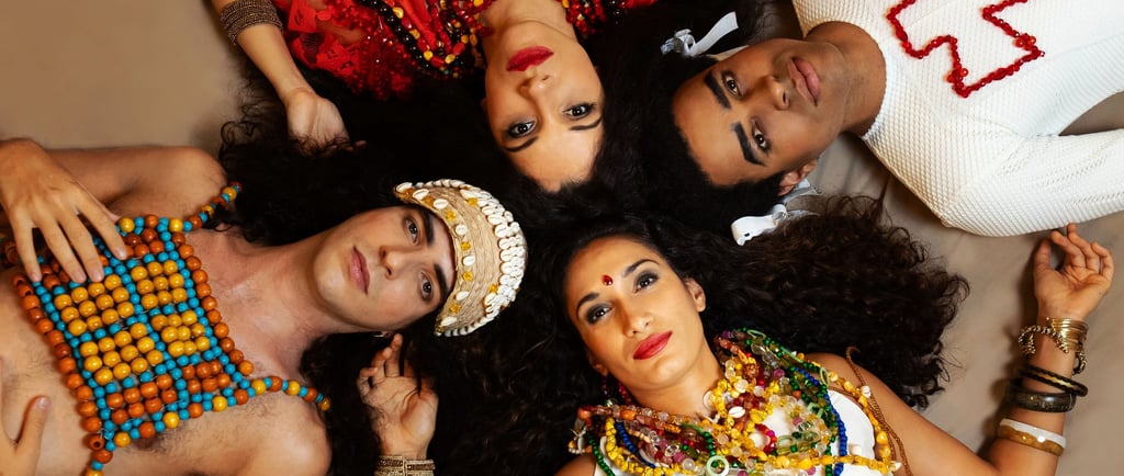 Four people in traditional Indian jewelry and colorful attire lying in a circle for a cultural portrait.
