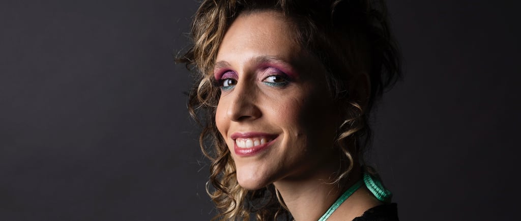 a woman with a black top and a green necklace
