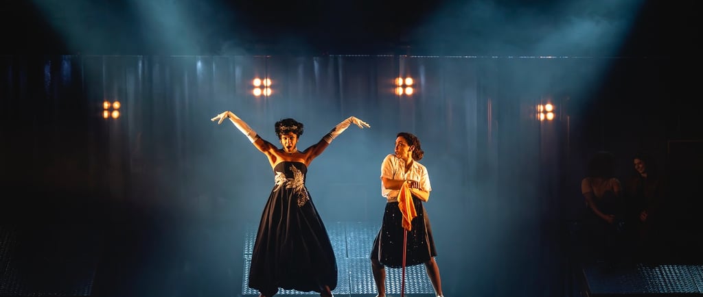 two women in black dresses on stage with lights