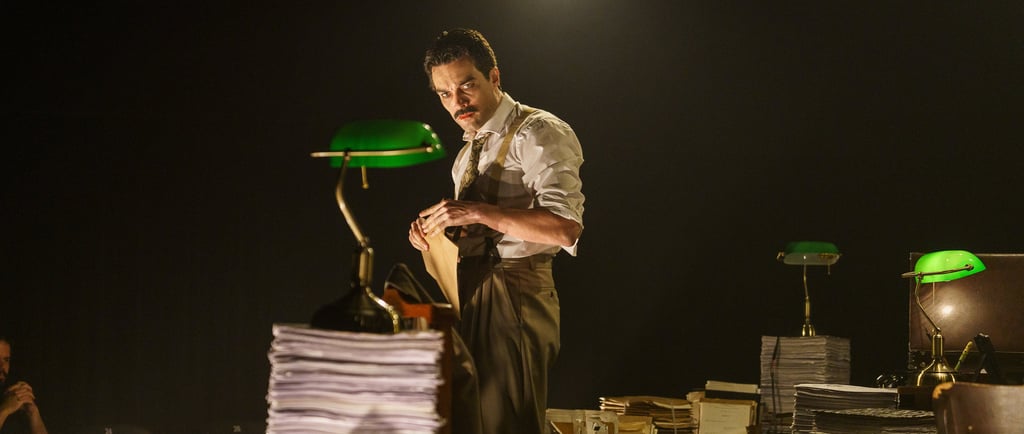 a man standing in front of a pile of papers