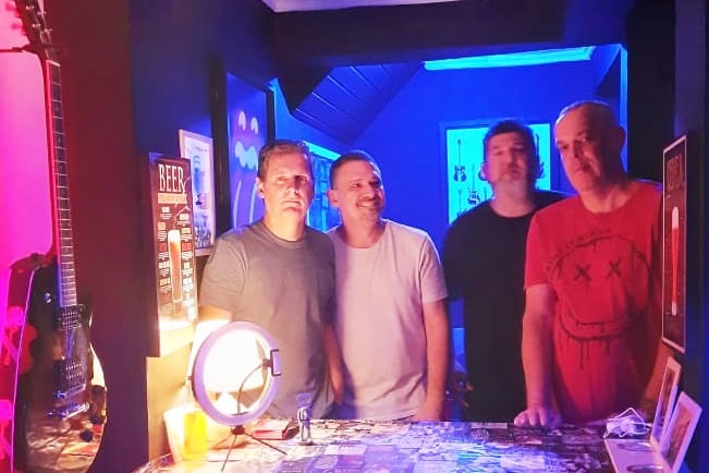 a group of men standing around a table with a mirror
