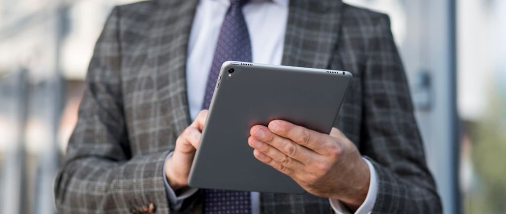 Alt txt: Profissional em ambiente corporativo utilizando tablet para empresa, com foco em mobilidade