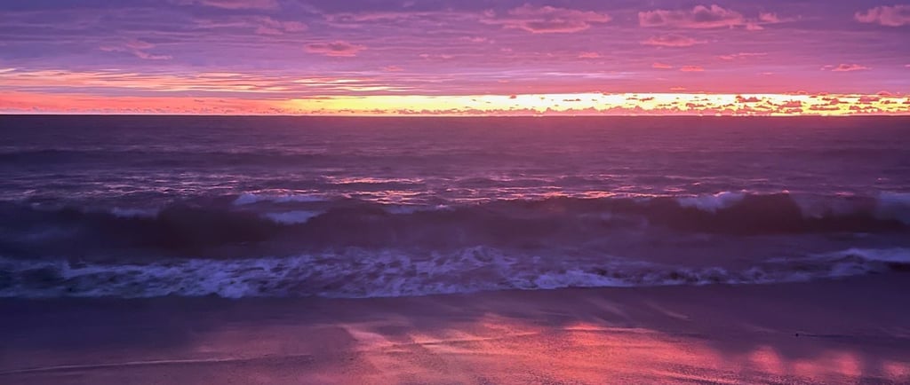 Coucher de soleil rosé à Canggu, Bali, ciel pastel reflété sur la plage.