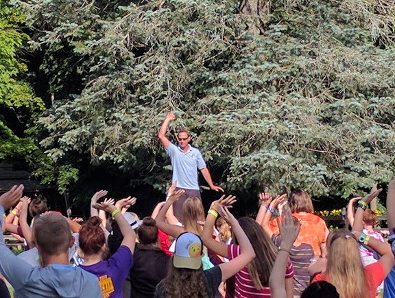 Johnny teaching children Tai Chi outdoors on a picnic table at Make Arthritis Stop Hurting Camp