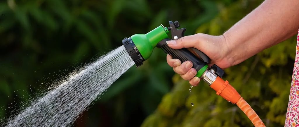 Arrosage précis au pistolet réglable sur un balcon, geste simple pour économiser l’eau