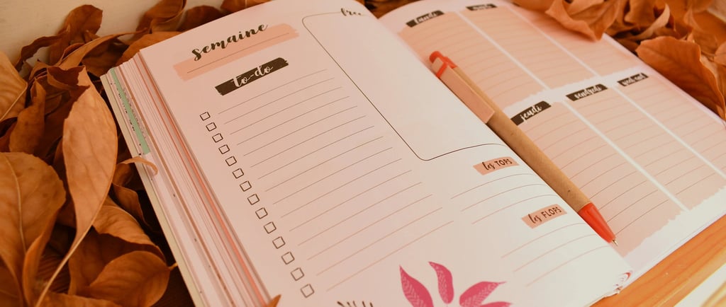 Planner hebdomadaire ouvert sur une page to-do, posé sur un lit de feuilles mortes