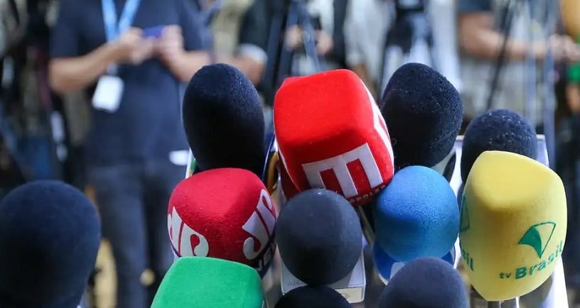 Microfones de jornalistas em uma coletiva de imprensa com advogados