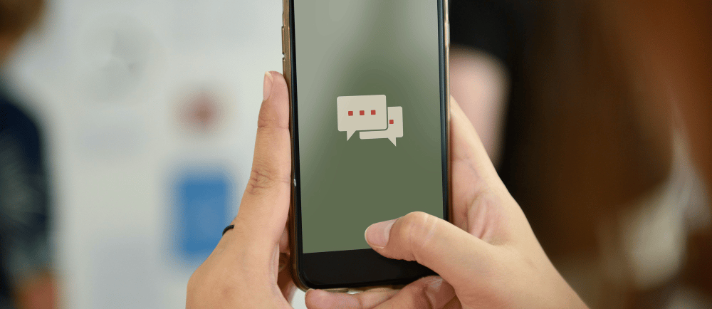 Pessoa com um celular na mão trocando mensagens