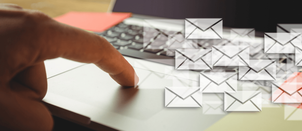 Mão em um notebook com ícones de e-mails