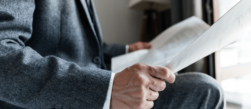Homem de paletó lendo jornal