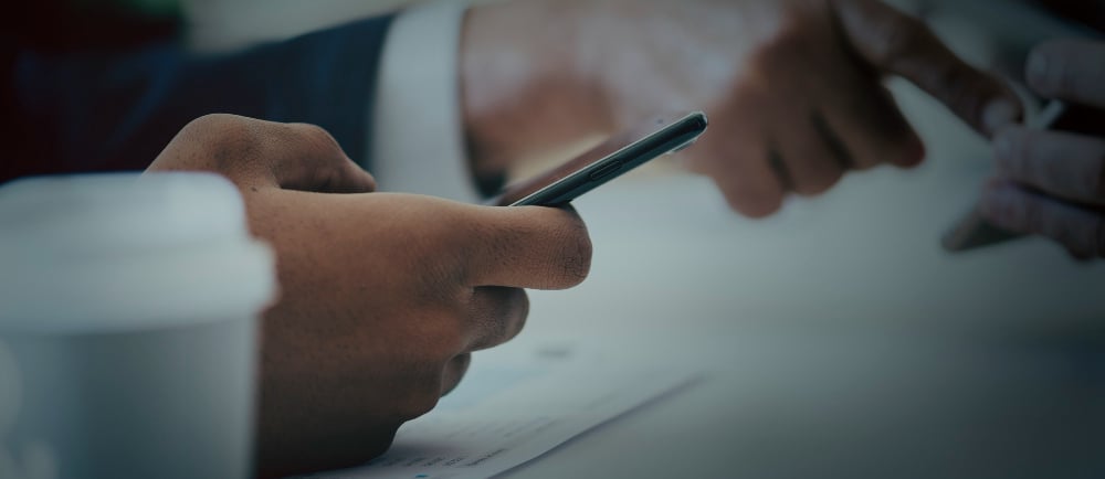 Advogado mexendo no celular em reunião