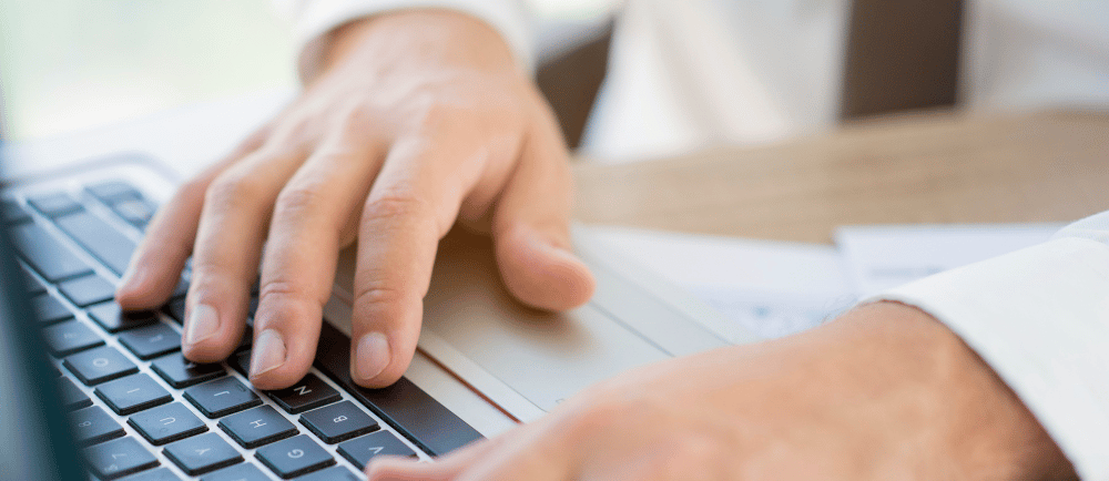 Home de paletó e gravata digitando em teclado