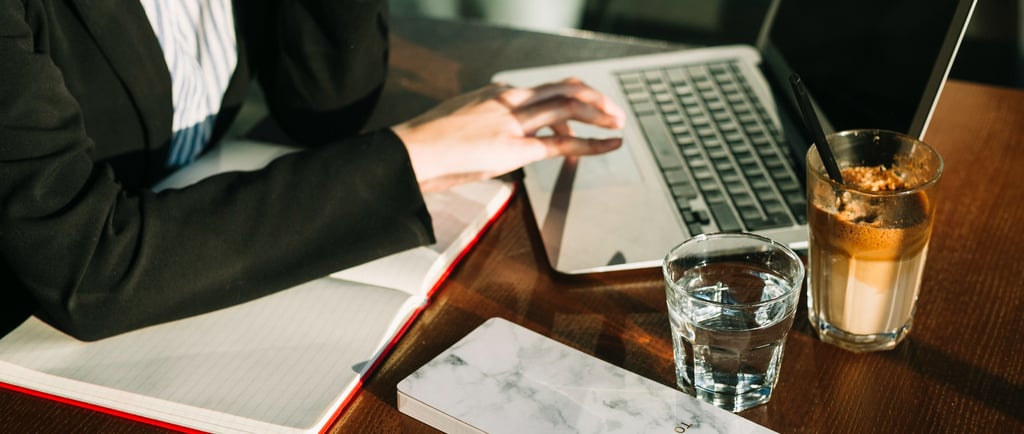 Advogada trabalhando em uma mesa fazendo tarefas de marketing jurídico no notebook