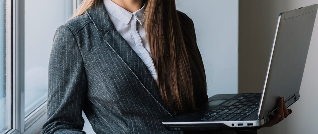 Advogada com roupa social segurando um notebook enquanto trabalha em ações de marketing jurídico