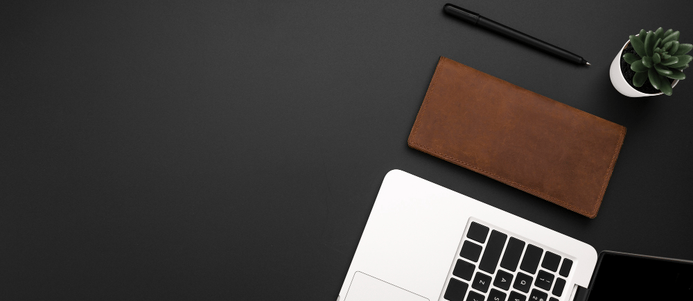 Carteira, caneta e notebook na mesa