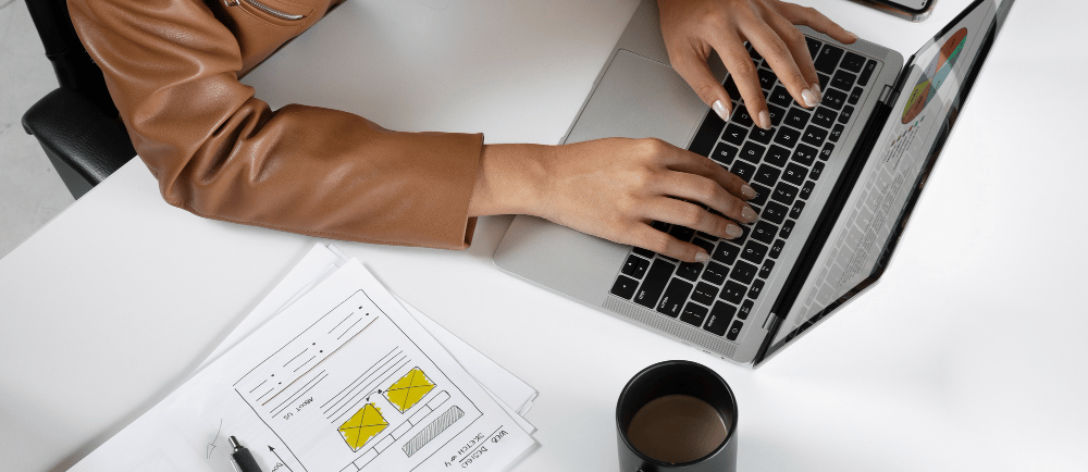 Webmaster programando landing page com notebook na mesa