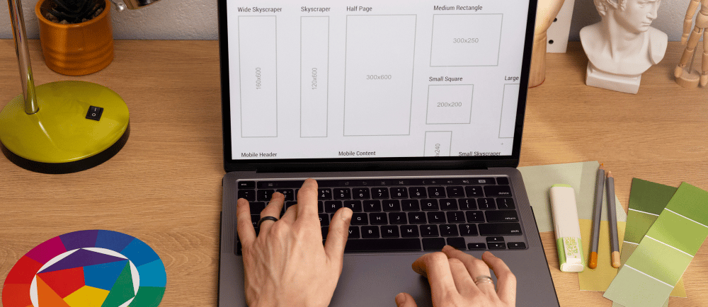 Mãos de um designer e tela do computador durante a produção de uma landing page